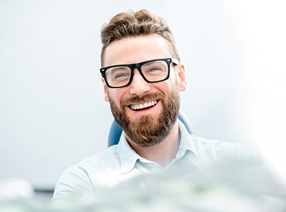 patient smiling while sitting in dental chair 