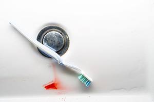 Toothbrush in sink with a bit of blood