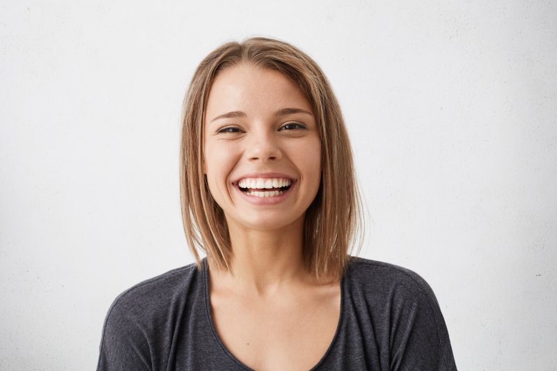 person who had cosmetic dental flaws fixed smiling