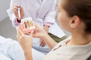 Dentist showing patient a model of a dental implant
