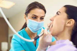 a dental hygienist cleaning a patient's teeth